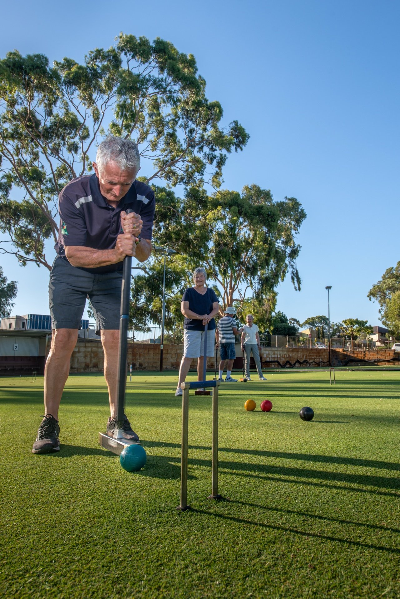 A club member playing a shot on the lawn at Cambridge Croquet Club